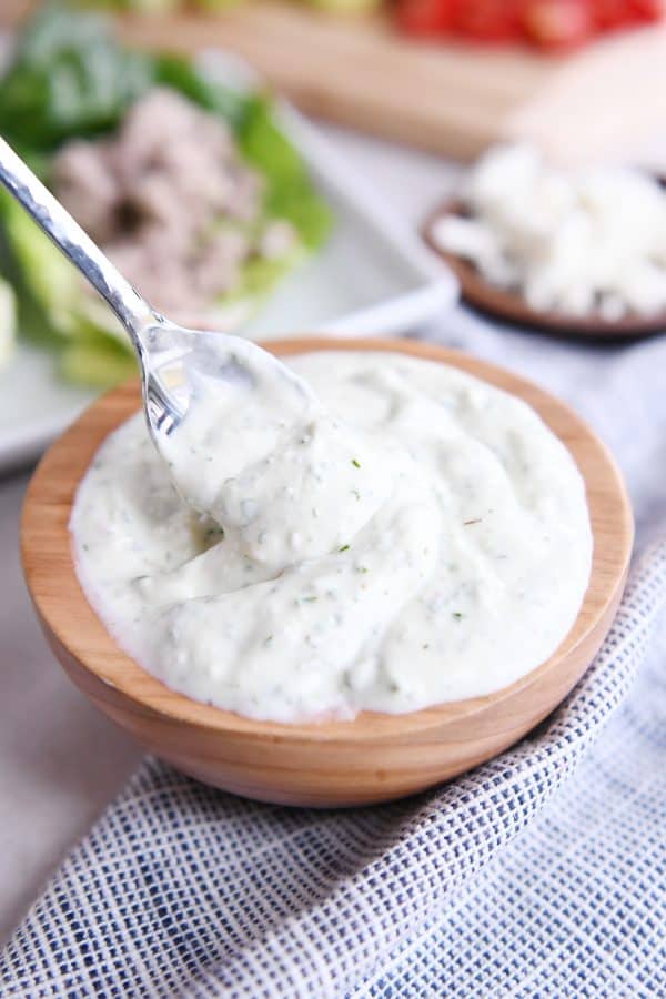 Spoonful in wooden bowl filled with mint feta sauce