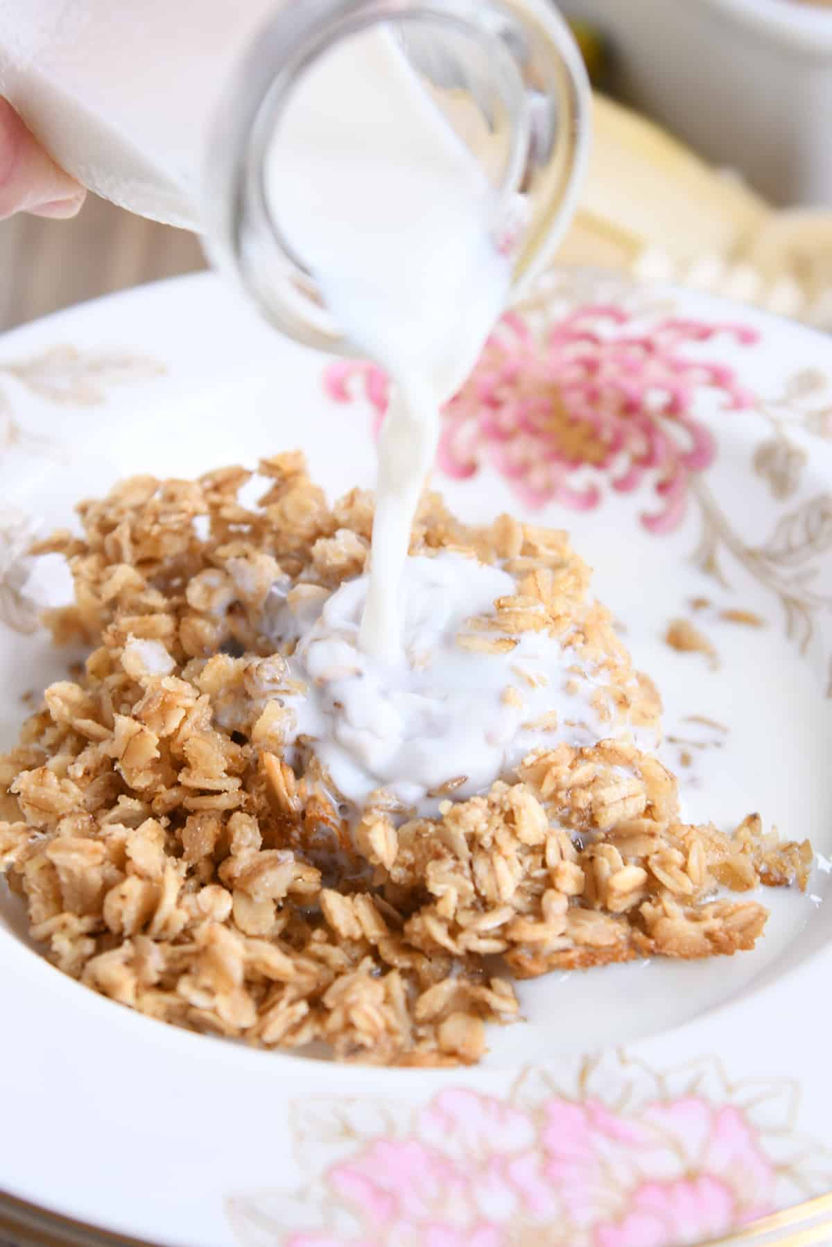 Pouring milk over bowl of easy Amish baked oatmeal.