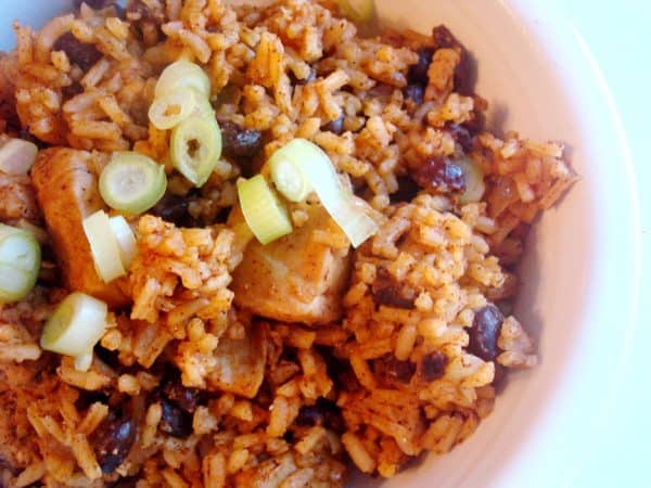 White bowl of chicken, black beans, and rice.