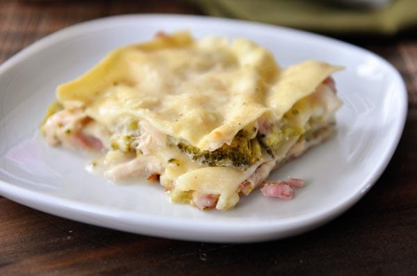 A square piece of chicken cordon bleu lasagna on a white plate.