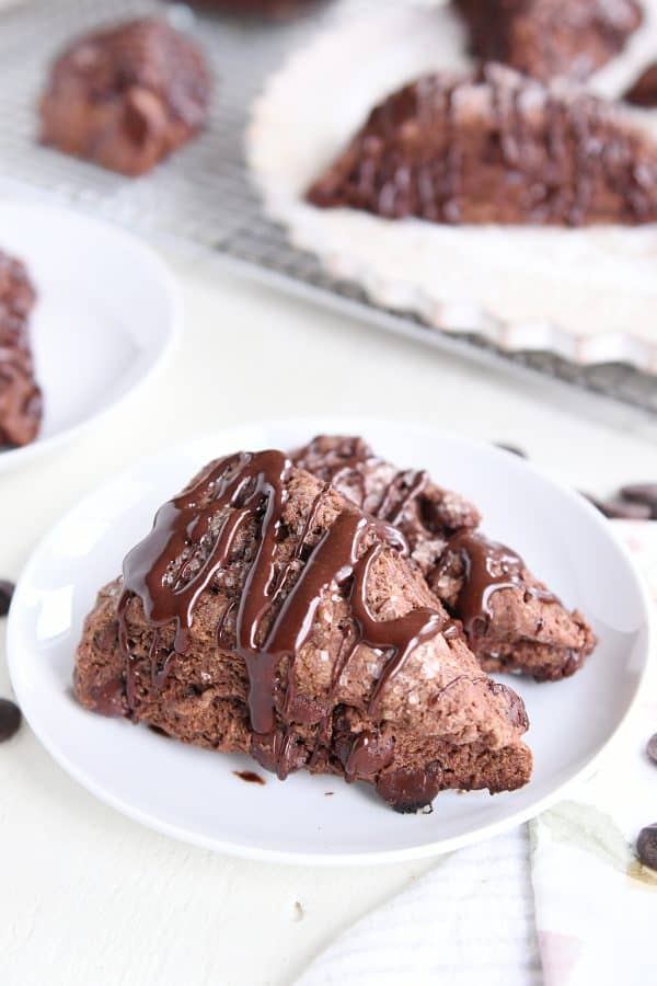 Two triple chocolate scones on white plate.