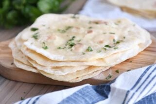 stack of easy yogurt flatbread on wood cutting board sprinkled with parsley