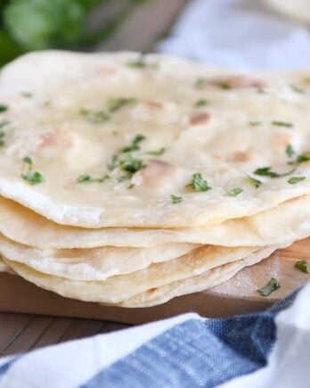 stack of easy yogurt flatbread on wood cutting board sprinkled with parsley