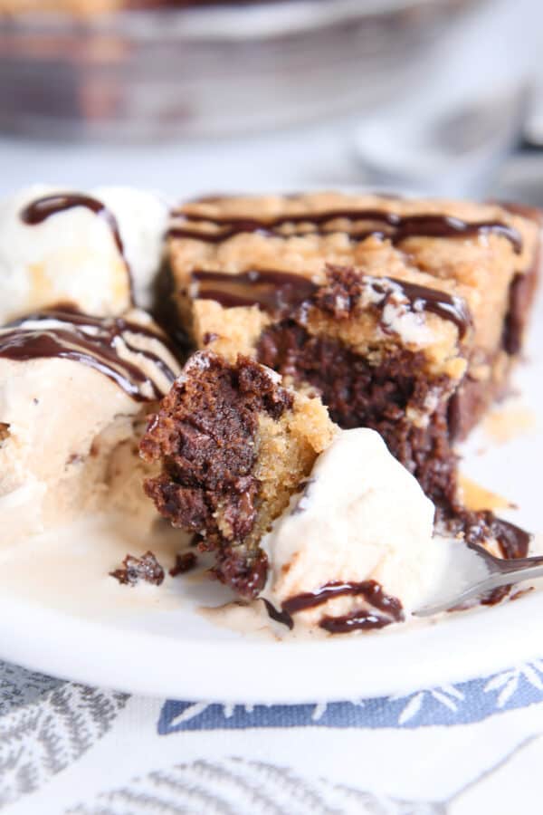 Ice cream, brooky pie, and drizzle of chocolate on a white plate