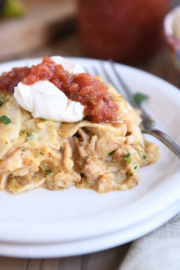 Close up of chicken enchilada casserole on white plate.