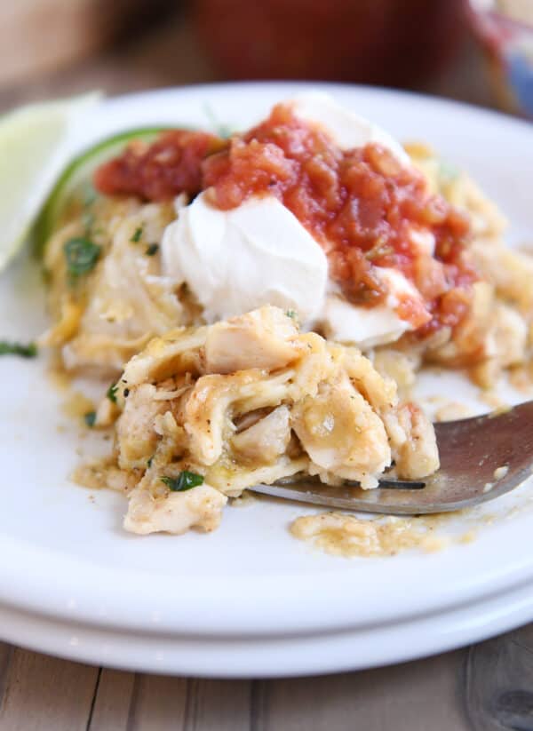 bite of chicken enchilada casserole on fork on white plate