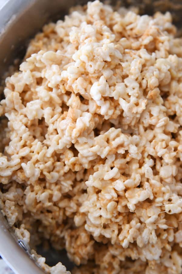 Mixed butterscotch rice krispie treats in metal saucepan.