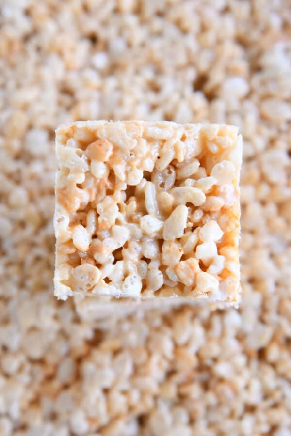 Square of butterscotch rice krispie treat on top of 9X13-inch pan of treats.