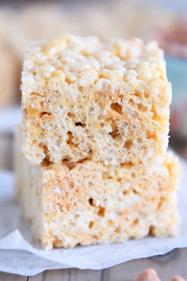 Two rice krispie treats stacked on piece of white parchment paper.