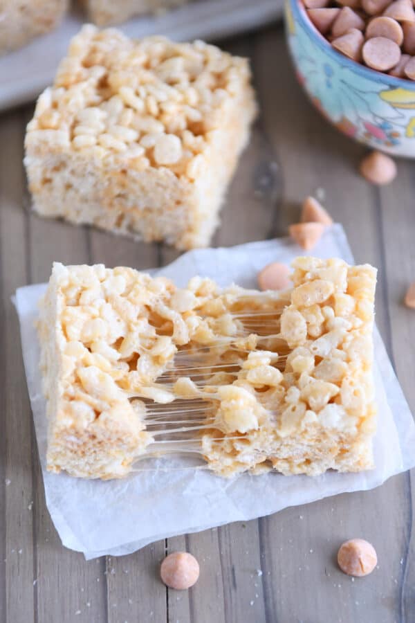 Butterscotch rice krispie pulled in half on white parchment paper.