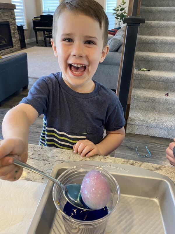 A little boy paints Easter eggs