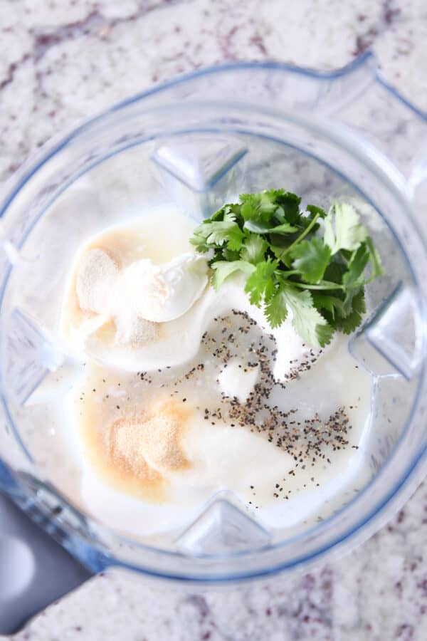 Blender with cilantro, pepper, garlic powder, cream cheese, buttermilk.