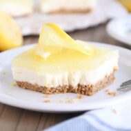 square of lemon white chocolate cream bar on white plate with bite taken out