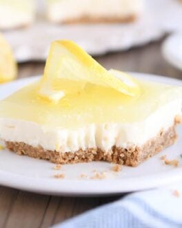 square of lemon white chocolate cream bar on white plate with bite taken out