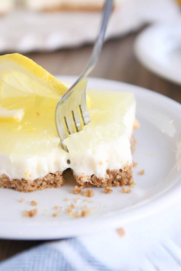 pulling a piece of lemon cheesecake bar away with fork