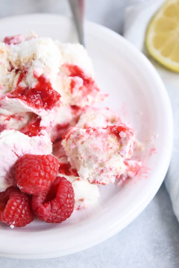 Top down view of white plate with raspberry cream angel food cake dessert.