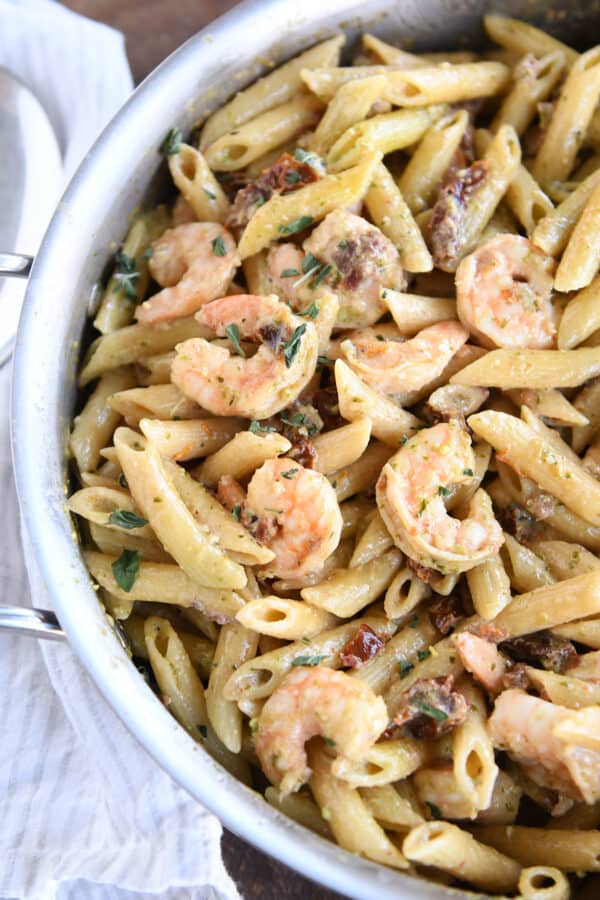 Top down view of easy shrimp pesto pasta in skillet.