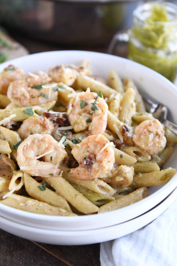 Shrimps, pasta, and dried tomatoes in two stacked white bowls