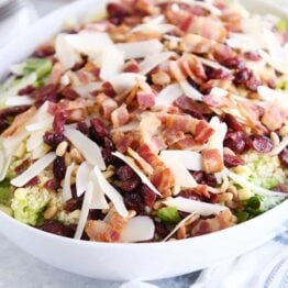 white serving bowl filled with salad ingredients for loaded fresh basil couscous green salad