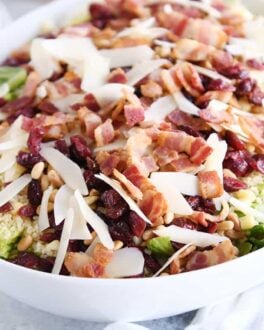 white serving bowl filled with salad ingredients for loaded fresh basil couscous green salad