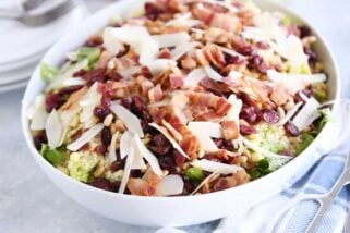 white serving bowl filled with salad ingredients for loaded fresh basil couscous green salad