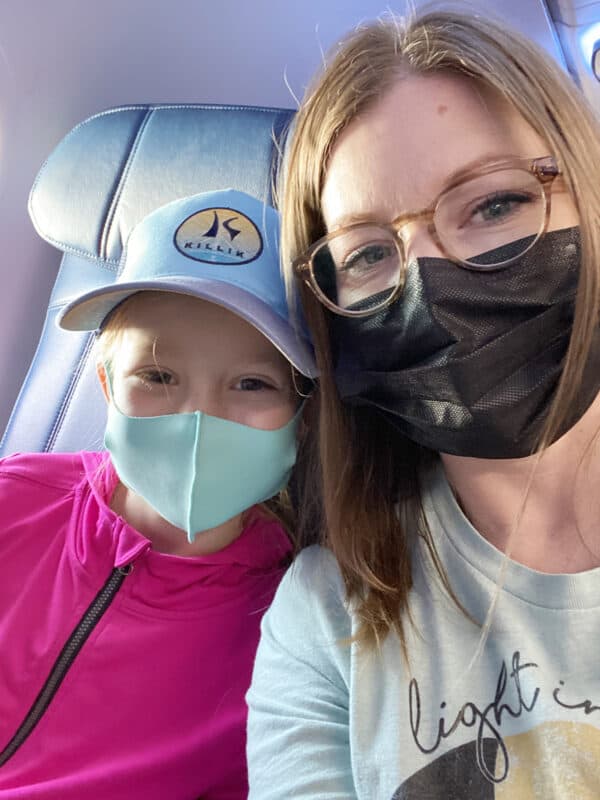 mom and daughter on plane with masks