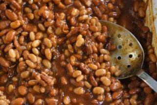 slotted spoon in dish of saucy baked beans