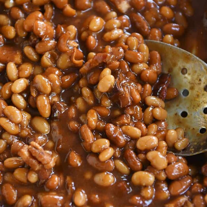 Slotted spoon in a plate of saucy baked beans