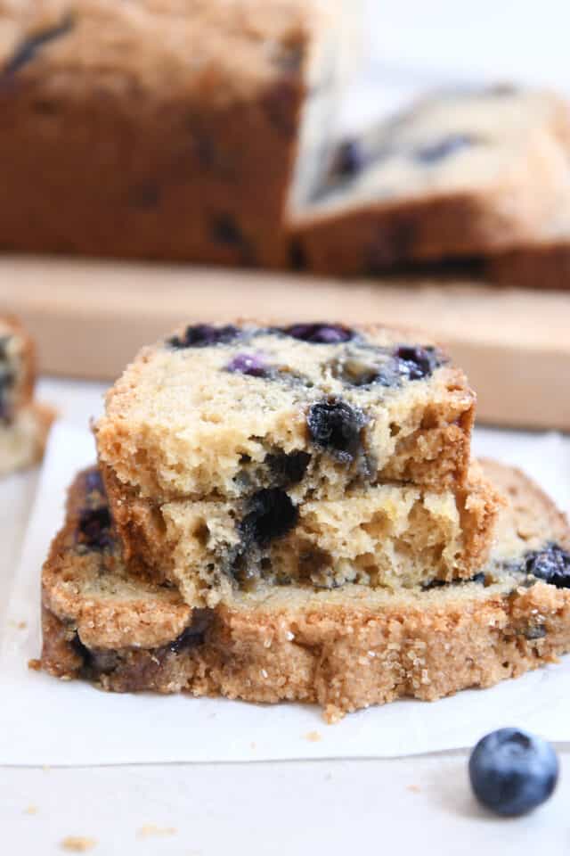 Two half slices of blueberry muffin bread on top of full slice.
