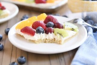 square of the best fruit pizza with bite taken out on white plate