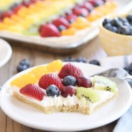 square of the best fruit pizza with bite taken out on white plate