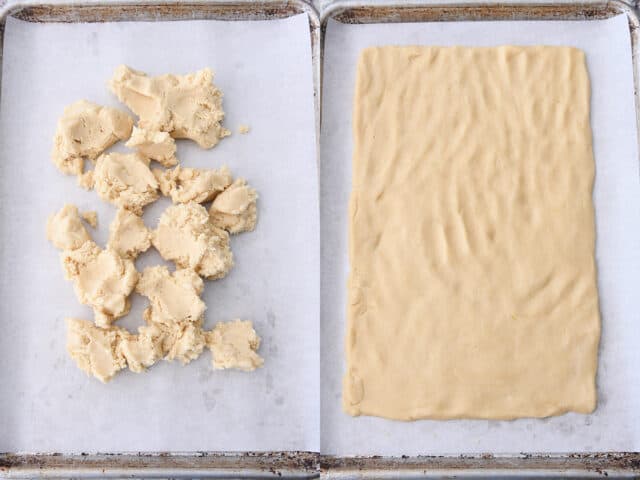 Sugar cookie dough crumbled on parchment lined sheet pan and then pressed into rectangle shape.