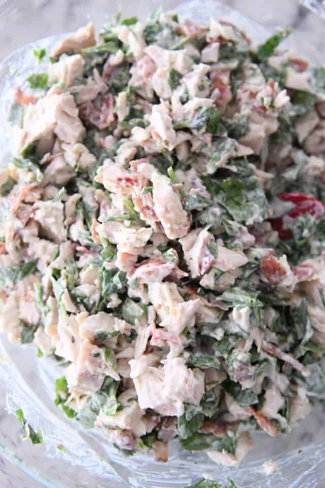 glass bowl with chicken, spinach, bacon and ranch dressing mixed together