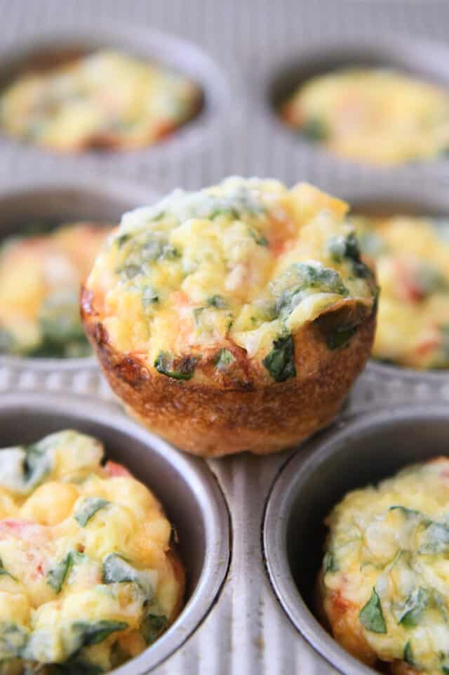 Baked hash brown veggie egg cup on top of muffin tin.