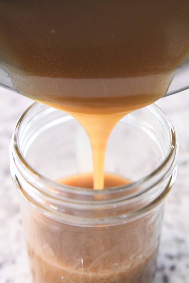 pouring butterscotch sauce into jar