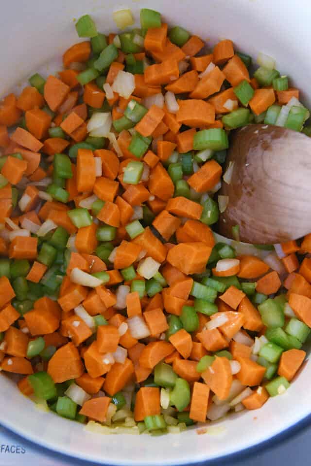 sauteeing carrots, onions, and celery in cast iron pot