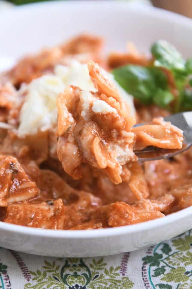 Scooping bite of one-pot chicken lasagna on fork.