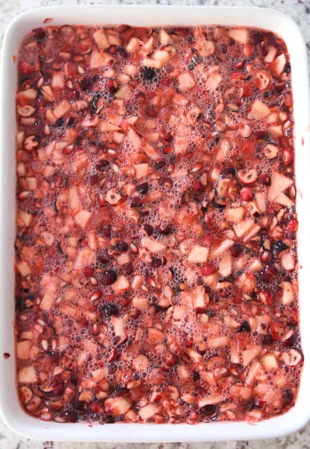 Top down view of cranberry pomegranate jello salad in white dish.