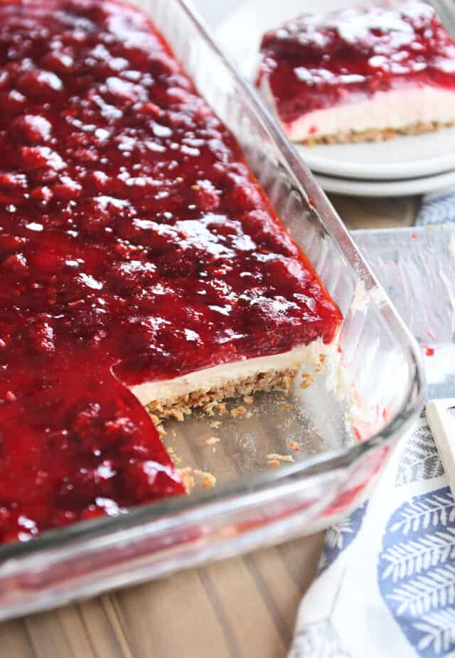 9X13-inch pan of raspberry pretzel jello with one corner square removed.