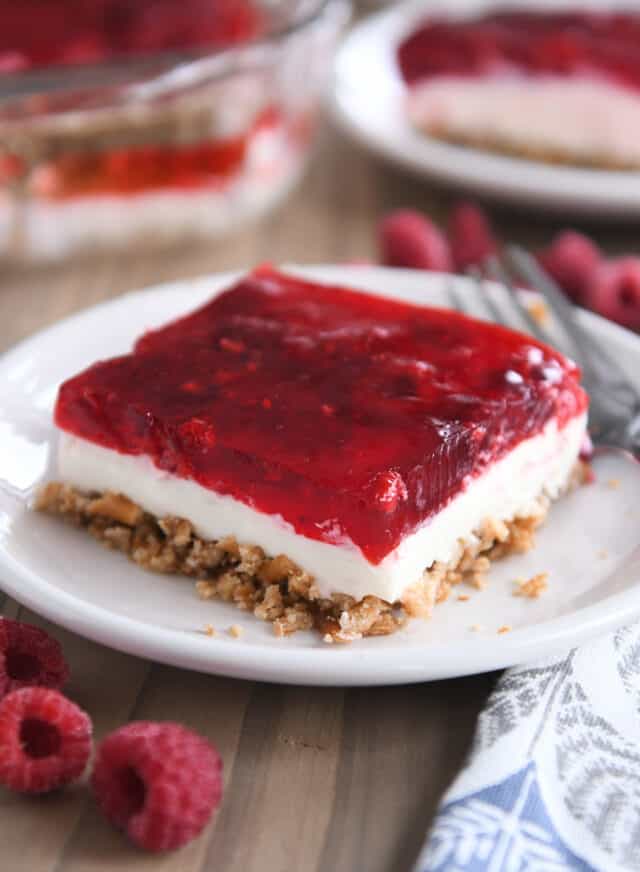 Square of raspberry pretzel jello on white plate.