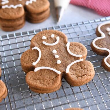 several decorated gingerbread people cookies on wire rack