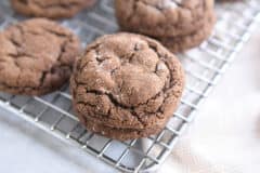 two chocolate ginger molasses cookies stacked on cooling rack