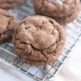 two chocolate ginger molasses cookies stacked on cooling rack