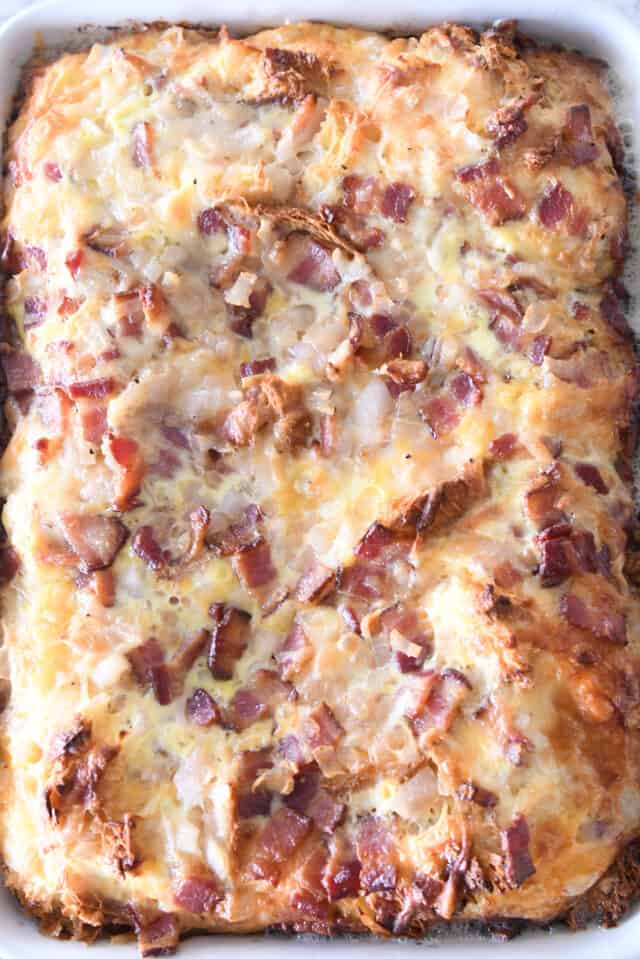 Puffy baked croissant casserole in white 9X13-inch pan.