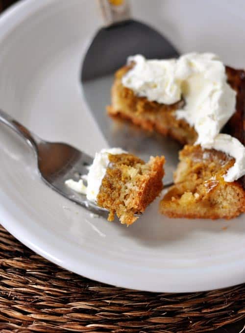 A slice of pumpkin sheet cake with a bite being taken out with a fork.