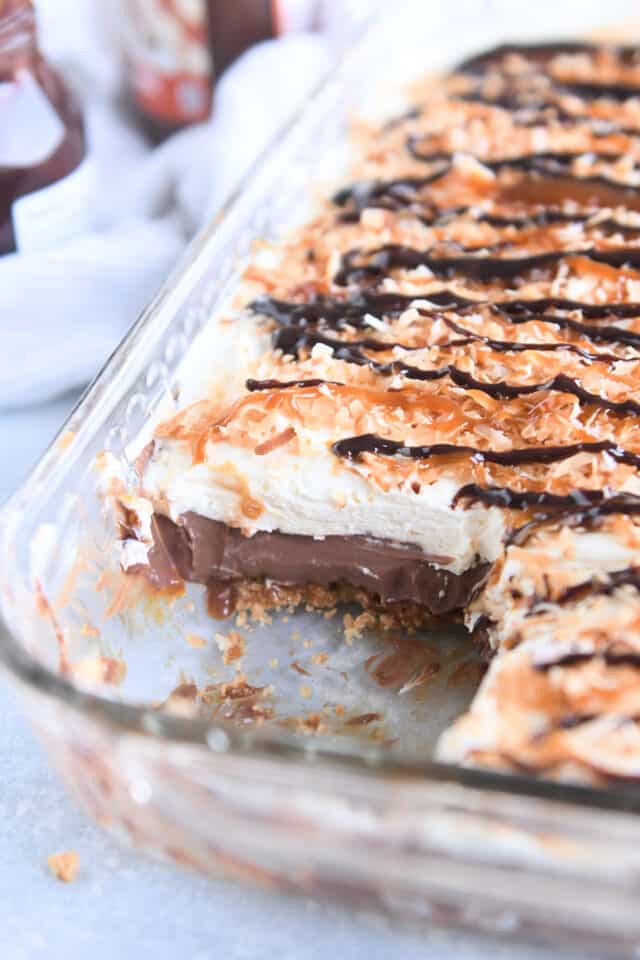 Pan of samoas chocolate pudding dessert with one square of dessert removed.