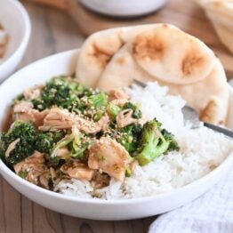 naan bread in white bowl with rice, chicken, broccoli and brown sauce