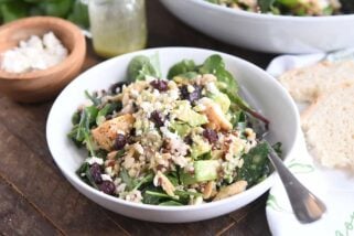 serving of kale and wild rice salad in white bowl with fork