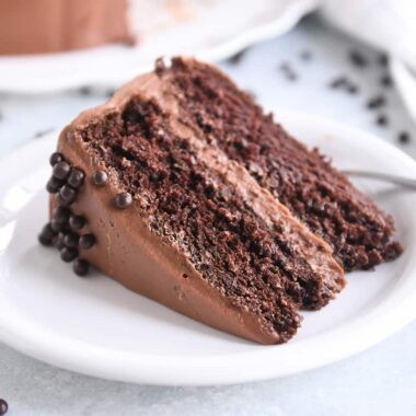 piece of chocolate cake with chocolate frosting on white plate