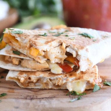 three triangle quesadillas with bite taken out of top quesadilla